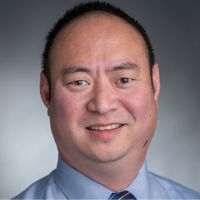 Portrait of a smiling man in a dress shirt and tie.